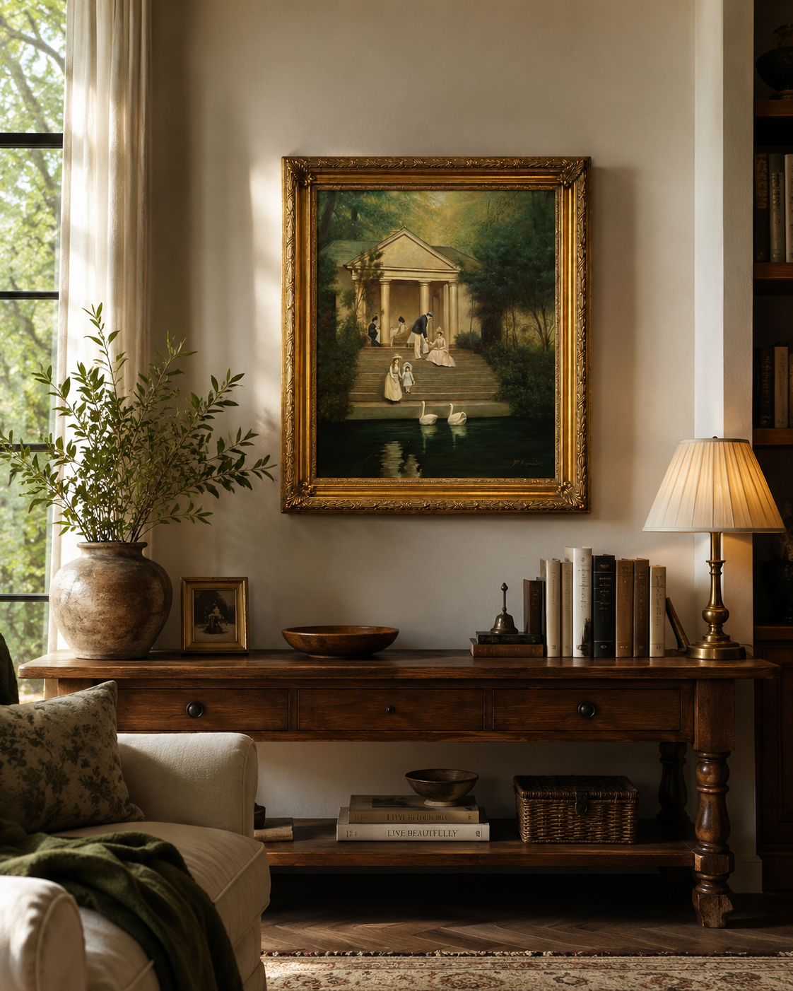 A classical landscape in a gilt frame above a wooden console